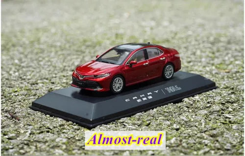 Red diecast model car on dark display base, detailed sedan with alloy wheels