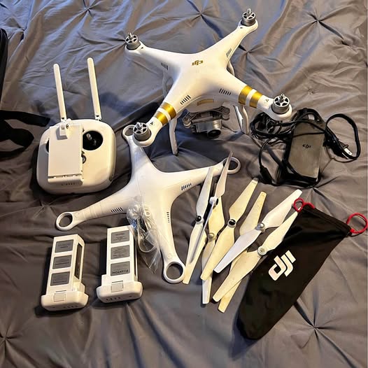White quadcopter drone with remote controller, batteries, and accessories