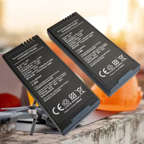 Two black drone batteries with printed specs and warning labels