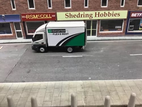 Diecast box lorry model with white cab and green stripe on the side