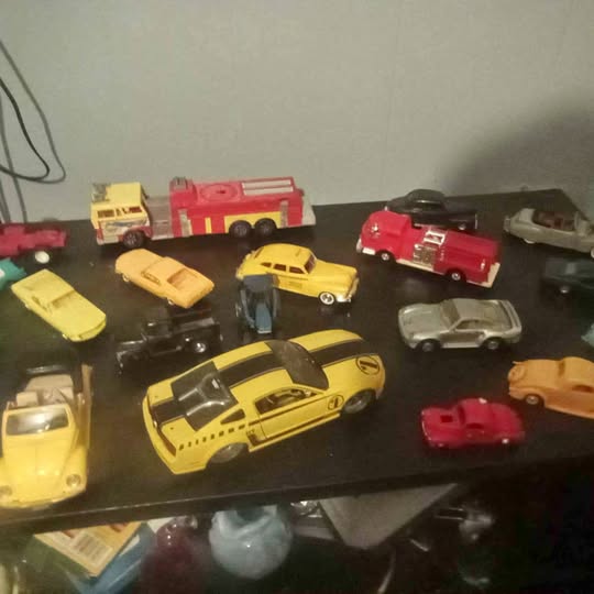 Diecast car and collectible assortment, multiple colored toy cars on display.