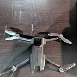 Grey mini drone with four propellers, top view.