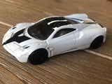 White diecast sports car with black wheels, 1:64 scale, side view