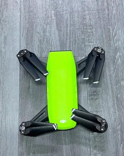 Green DJI Spark drone with four black propellers, lime body centered