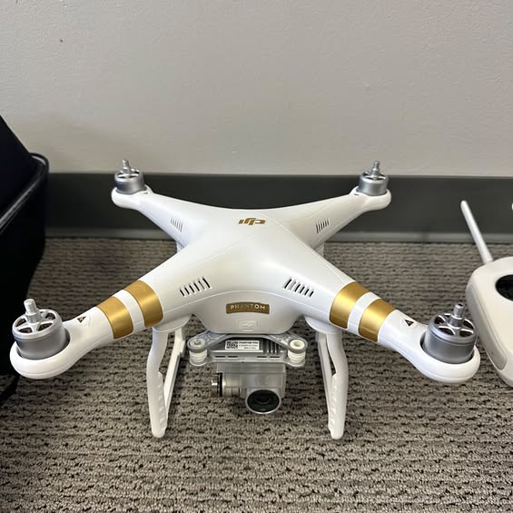 White quadcopter drone with gold accents, front camera and landing gear visible
