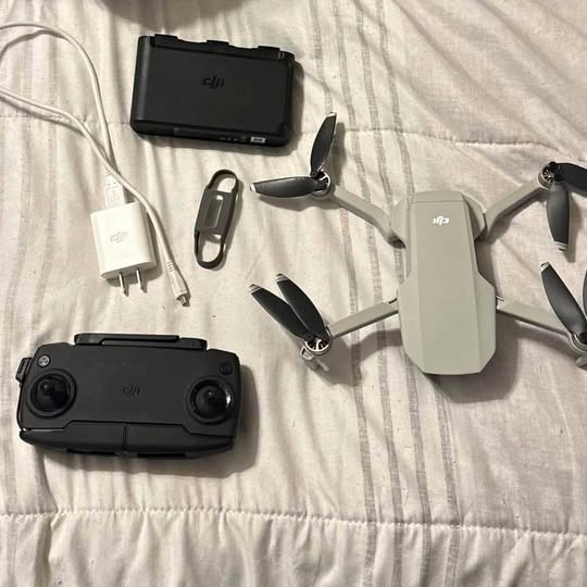 Foldable quadcopter drone with white body and black remote controller