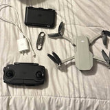 Foldable quadcopter drone with white body and black remote controller