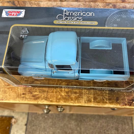 Light blue diecast pickup truck with detailed front and hood, shown in retail box