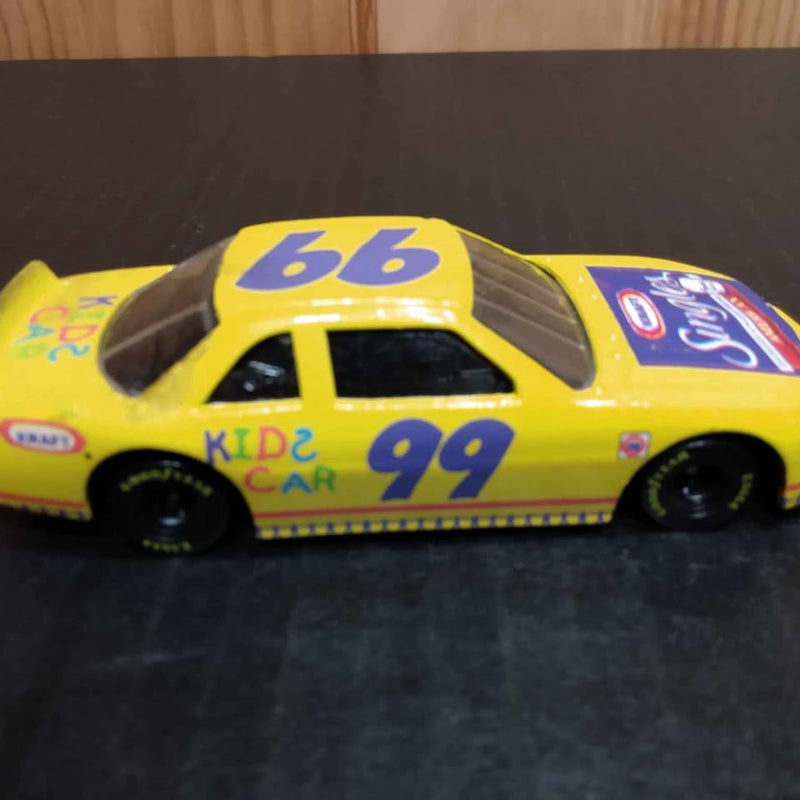 Yellow diecast race car with number 99, Kid e Car decals, front three-quarter view