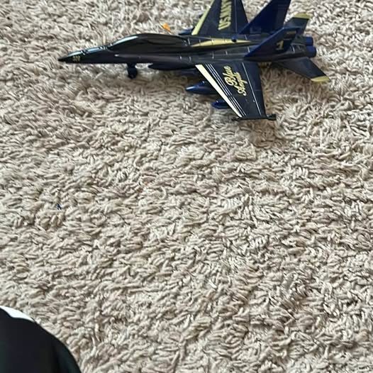 F-18 diecast fighter jet model, dark blue and black with yellow markings