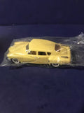 Yellow diecast model car in clear box, classic Tucker Torpedo shape