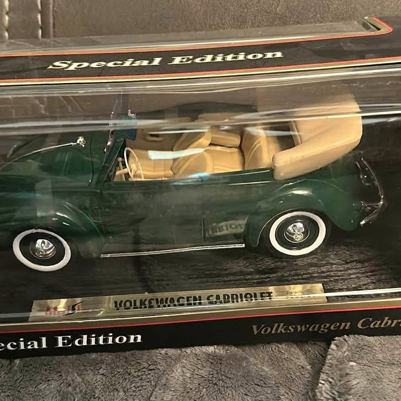 Green diecast convertible car model with beige interior, whitewall wheels, side view.