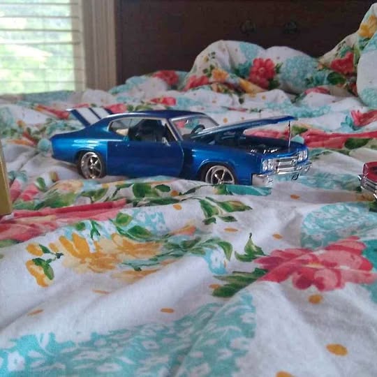Blue diecast Chevrolet Chevelle model car with open front grille and chrome wheels