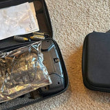 Black drone in zippered case with exposed components and protective plastic