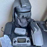 Gray drone with remote controller and padded carry bag