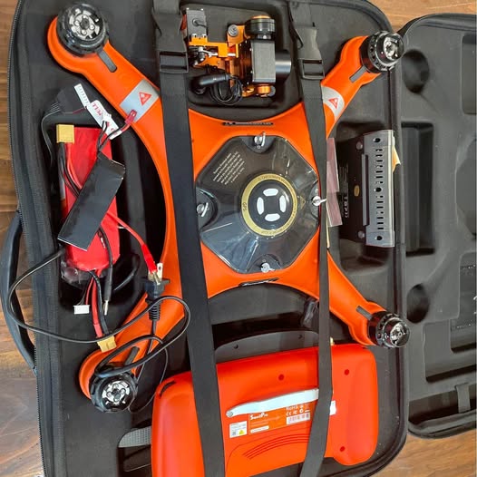 Orange and black drone components in hard-sided carrying case