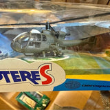 Green-gray diecast helicopter model with rotor and landing gear, in blister packaging