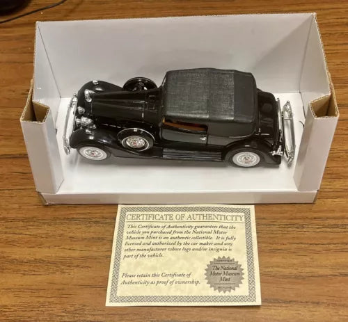 Black classic diecast model car in box with certificate of authenticity