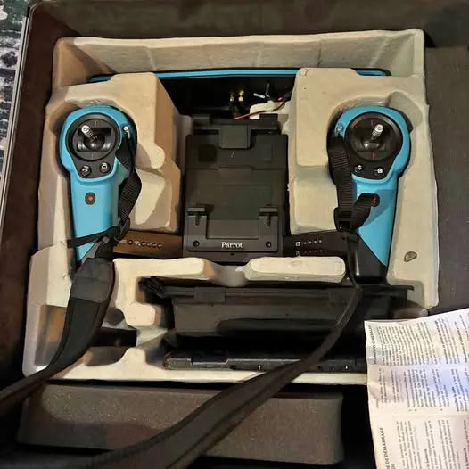 Turquoise drone controller with twin grips, in protective foam box