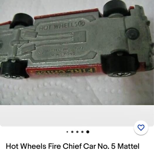 Vintage diecast toy car with gray body, black wheels, and red stripe