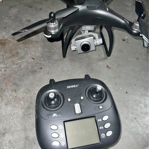 Black drone controller with two joysticks, LCD screen, and button controls