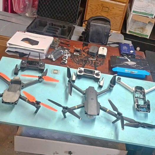 Quadcopter drone with spare parts and accessories, laid out on a work surface
