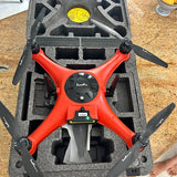 SwellPro orange quadcopter drone with four black propellers in foam case