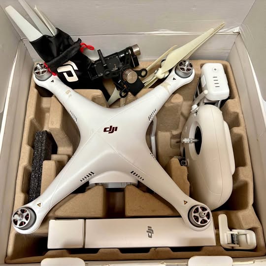 DJI drone with white body, four propellers, and mounted camera module