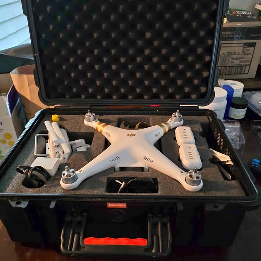 White quadcopter drone with controller, inside a hard protective case