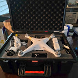 White quadcopter drone with controller, inside a hard protective case
