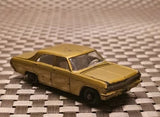 Vintage diecast model car in gold-brown with black trim, front 3/4 view