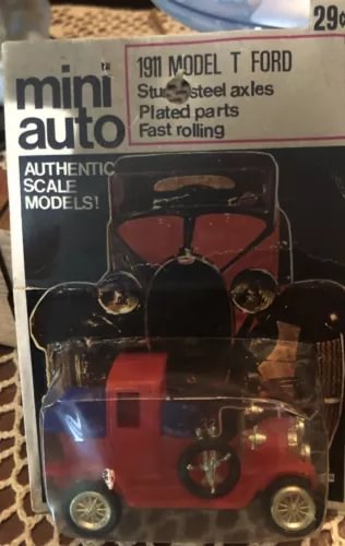 Vintage diecast toy car, red body with black top and gold wheels