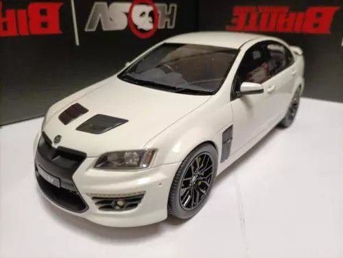 White diecast model car, front 3/4 view with black hood vents and alloy-style wheels