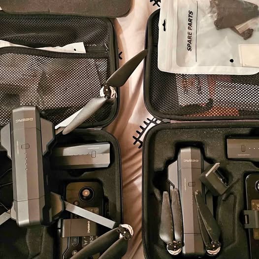 Portable drone carry case with folded quadcopter and spare parts compartments