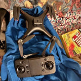 Dark gray quadcopter drone with four propellers and handheld controller