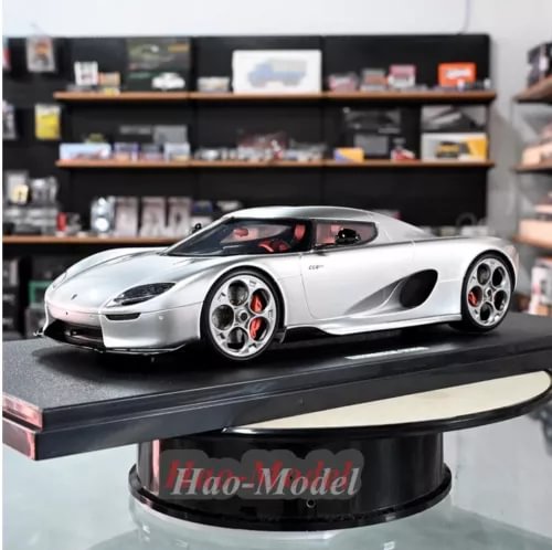Silver 1/18 diecast model car with black hood and red brake calipers, front 3/4 view