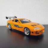 Orange Jada diecast sports car model with black hood stripe and front splitter