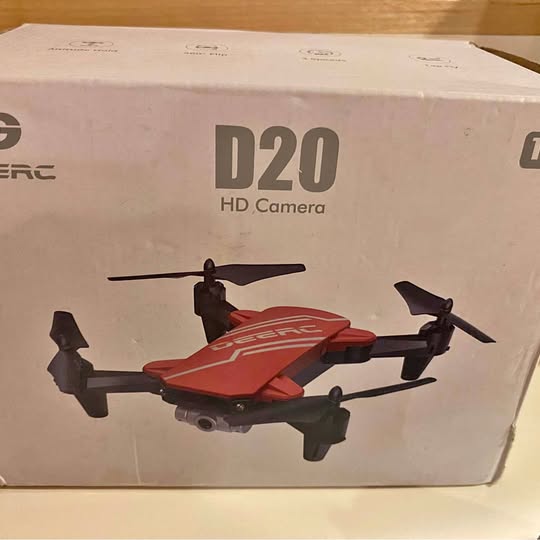 Red quadcopter drone with HD camera, shown on product box