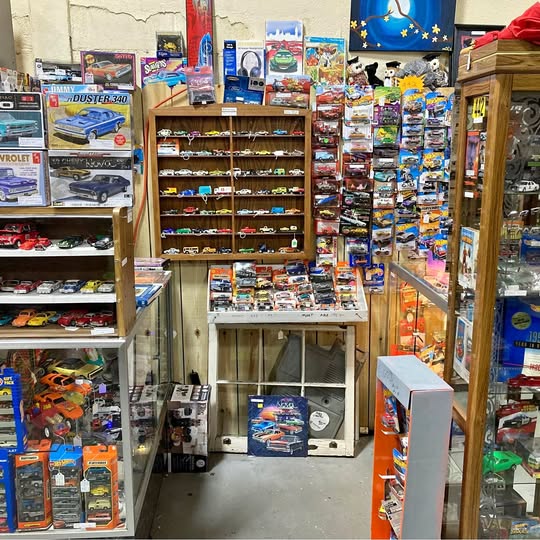 Retail display of diecast slot cars and model kits in boxed packaging on shelves