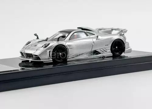 1:64 scale silver racing diecast model car with black wheels on base