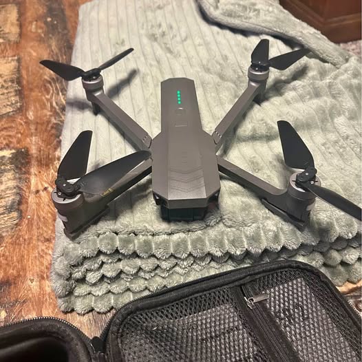 Gray foldable quadcopter drone with phone remote controller and charging stand
