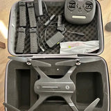 Gray camera drone in open hard-shell case with accessories and spare parts