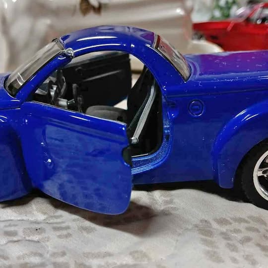 Blue diecast pickup truck with open door and detailed cabin view