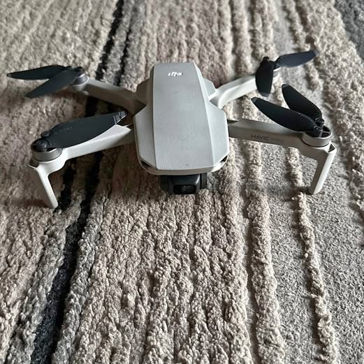 DJI folding quadcopter drone with 4 propellers, light gray body
