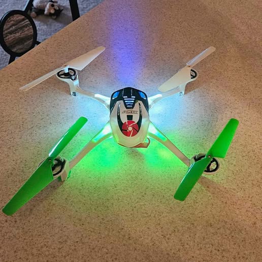 Traxis stunt drone with four green propellers and LED lights, top view
