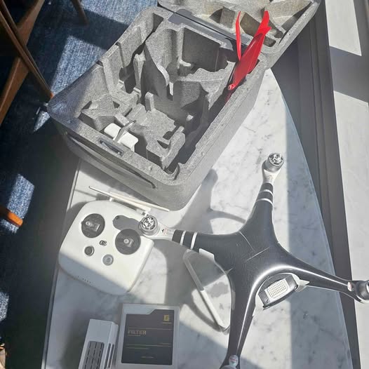 DJI Phantom 4 drone with gray body and red propellers, shown with controller