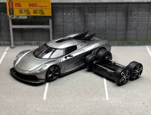 Grey diecast racing sports model car, front three-quarter view, with separate black base