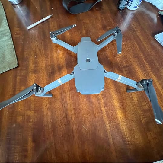 DJI Mavic Pro drone with four blue propellers and light gray body, top view