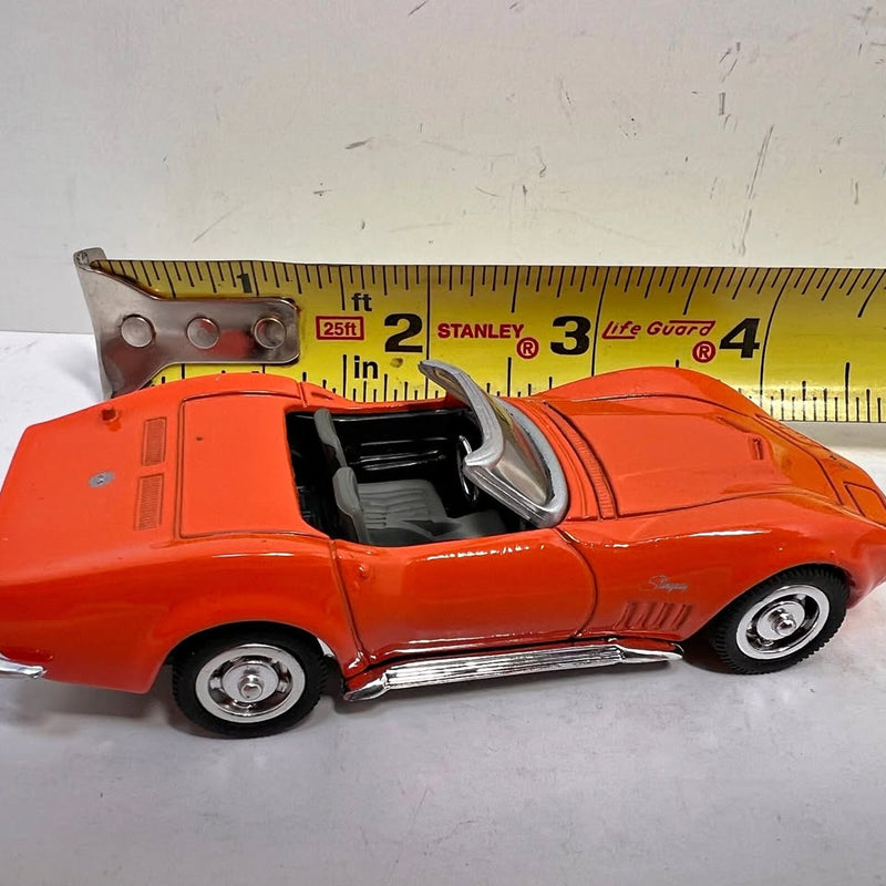 Orange 1:43 scale diecast convertible car model, front-side view with open top