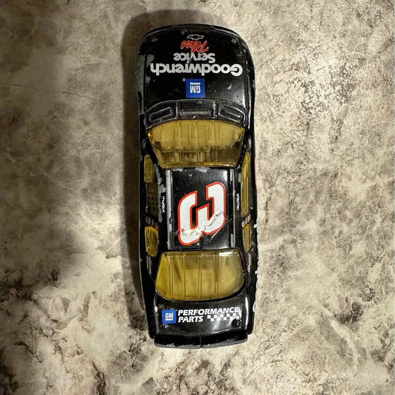Diecast race car in black with yellow interior and red white number 3 on hood